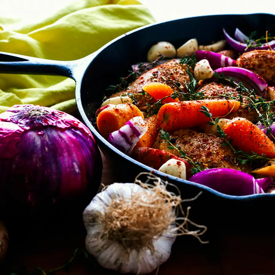 Chicken thighs roasted with carrots and onions in a pan