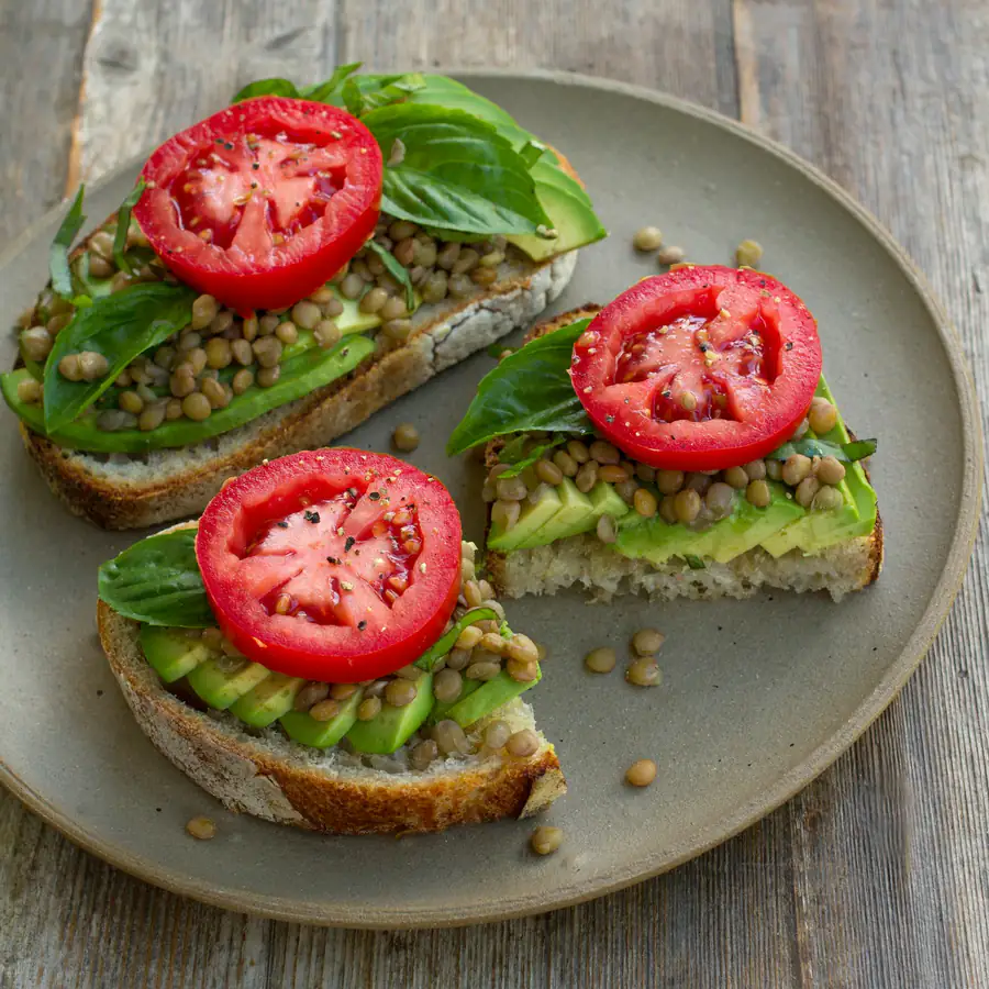 Toast topped with smashed green beans and tomato