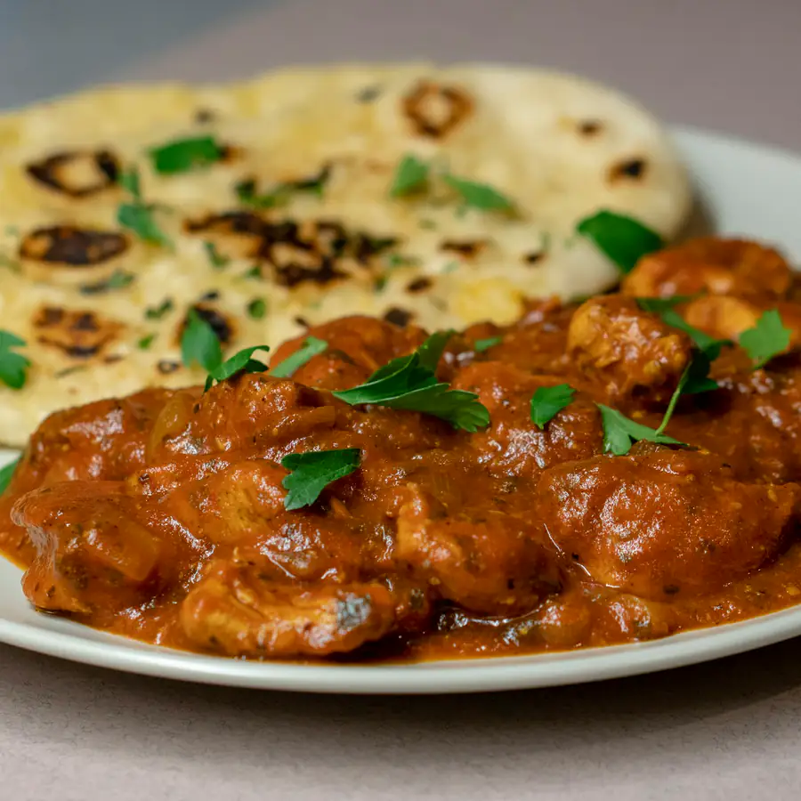 Plate of chicken tikka masala with naan bread