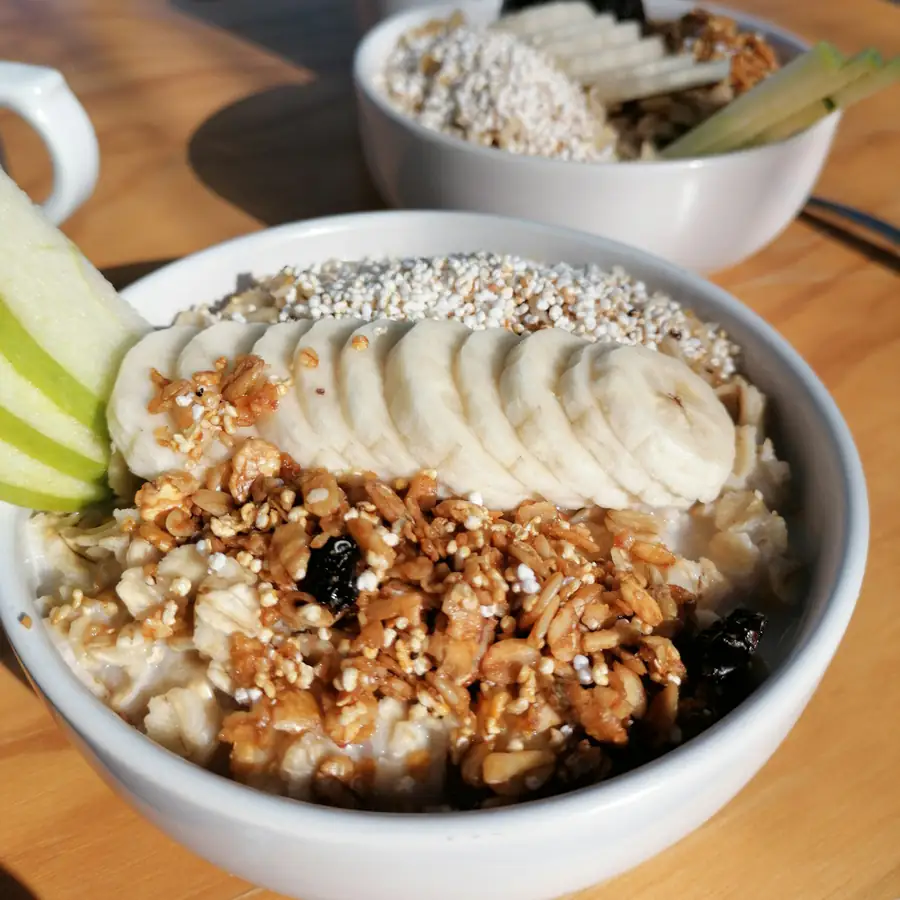 Bowl of porridge topped with banana and grains