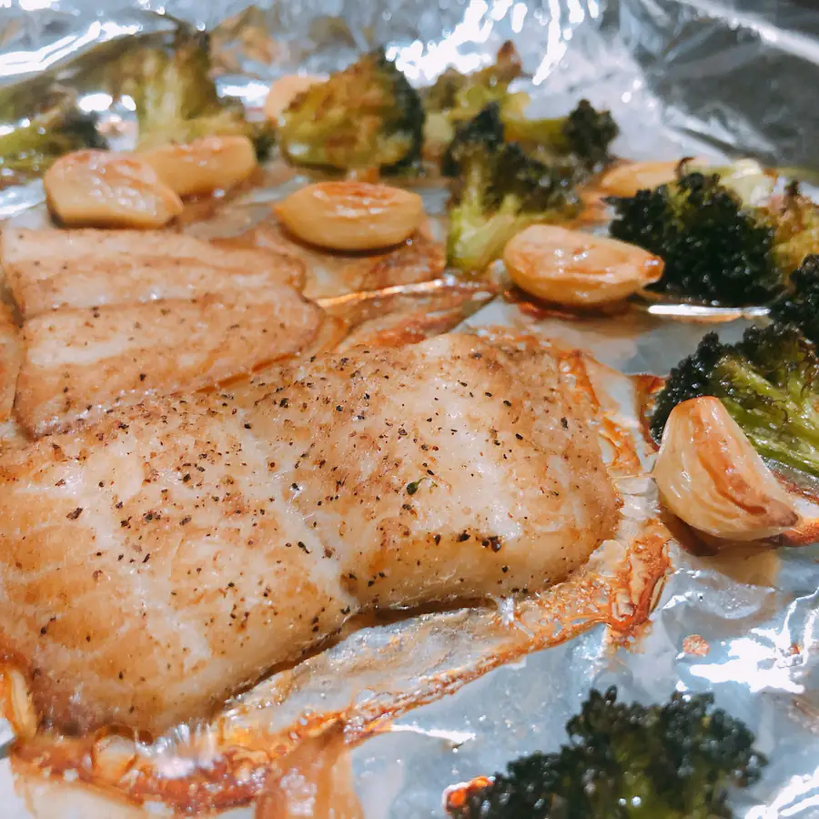 Salmon fillet baked on foil with broccoli florets and prawns