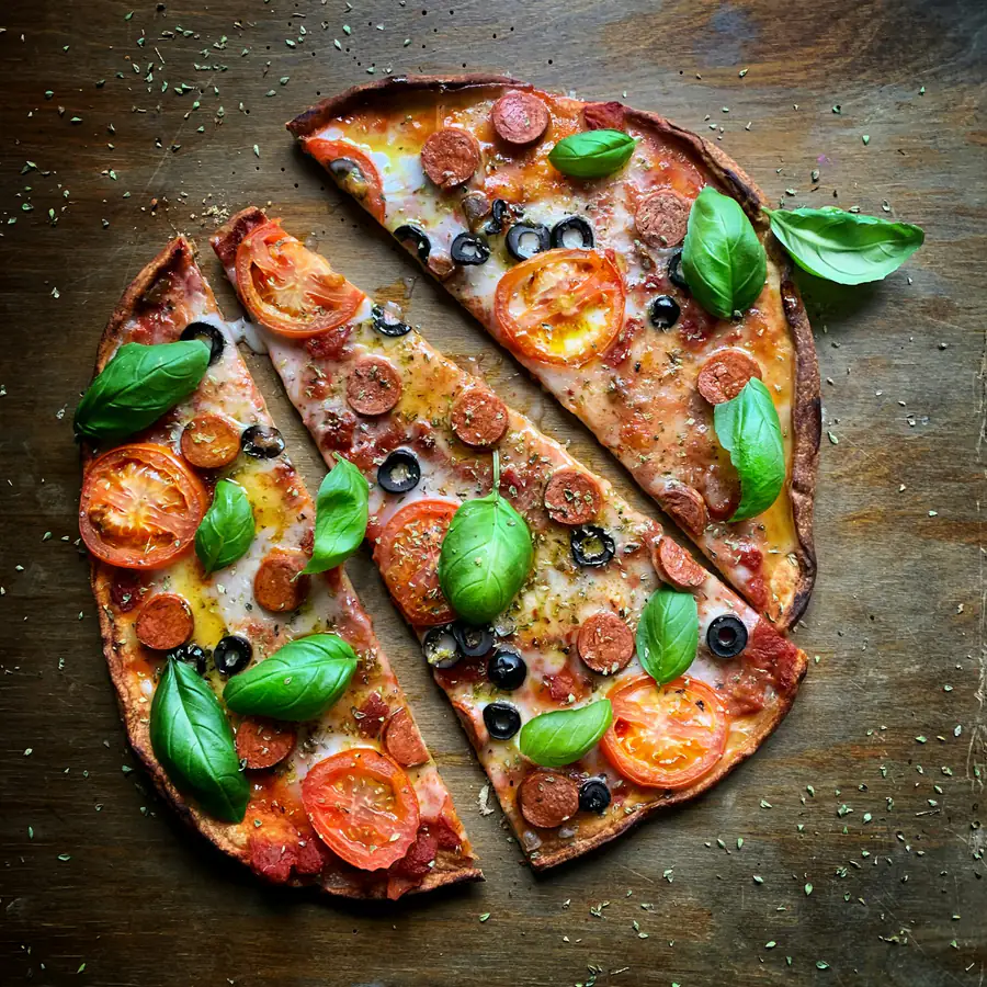 Thin crust vegetable pizza cut into slices
