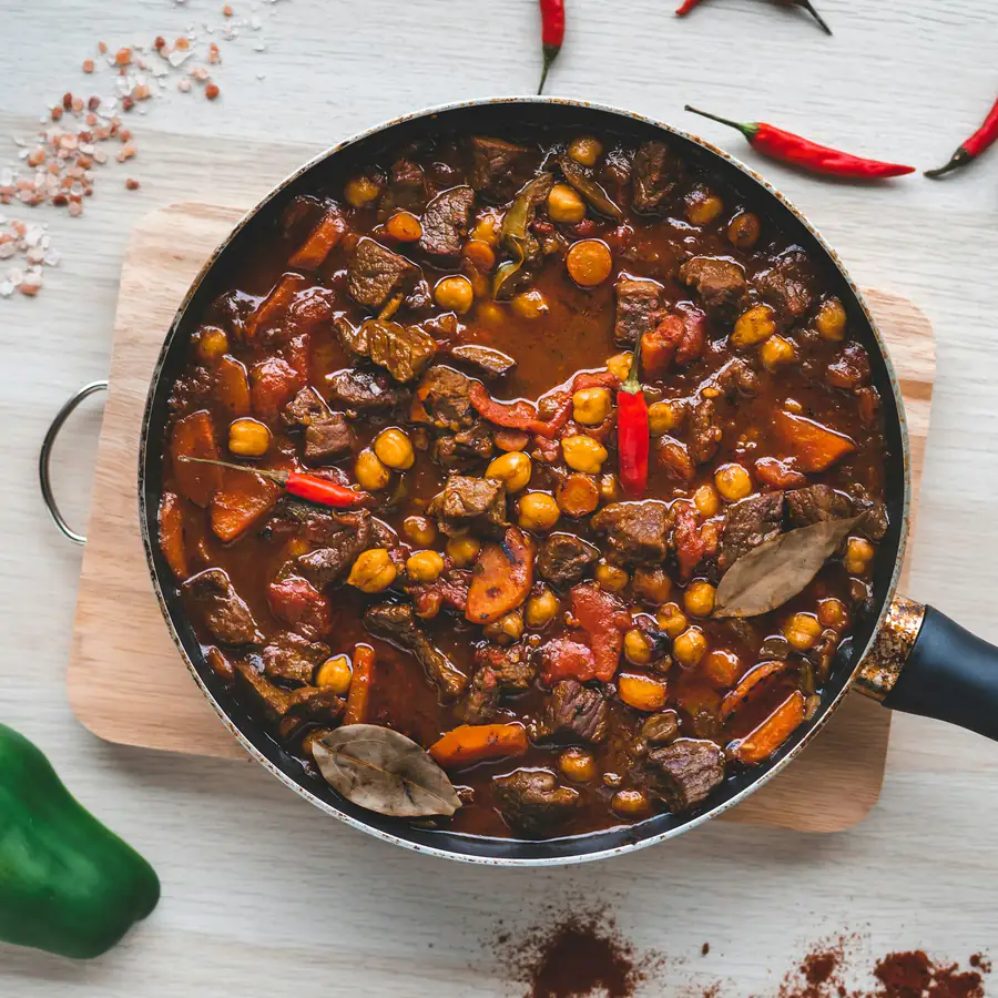 Pan of stew with meat, carrots, chickpeas and chillies