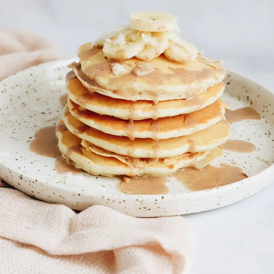 Stack of banana pancakes with banana slices