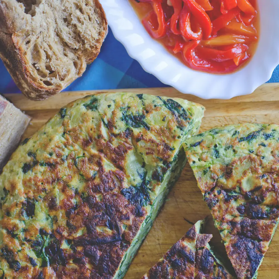 Slices of Spanish omelette with bread and tomato