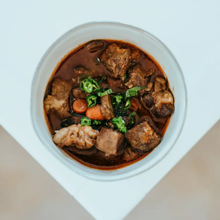 Bowl of beef stew with carrot, parsnip and herbs