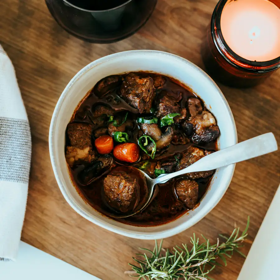 Bowl of lamb stew with carrots and herbs