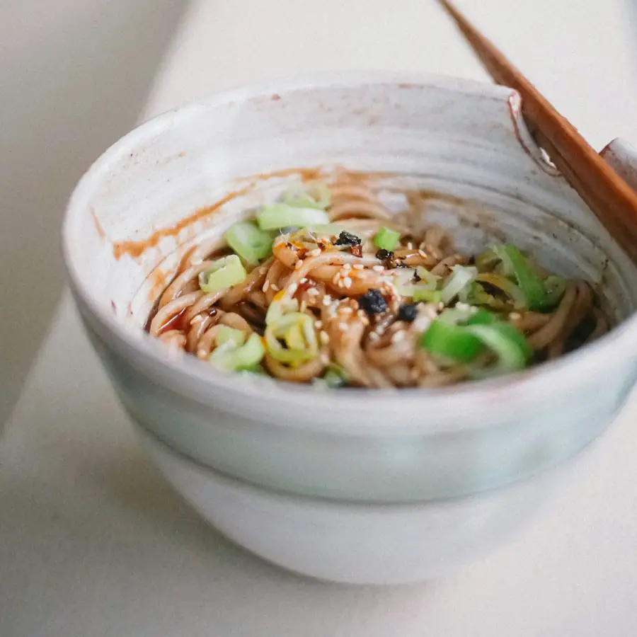 Bowl of peanut noodles with crunchy vegetables