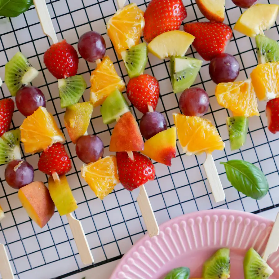 Rainbow fruit kebabs on a rack