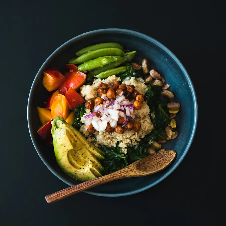Bowl of quinoa salad with greens, feta and olives