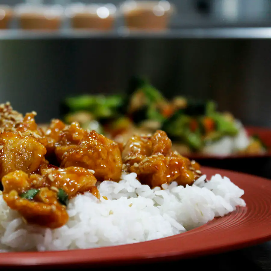 Plate of rice topped with glazed chicken