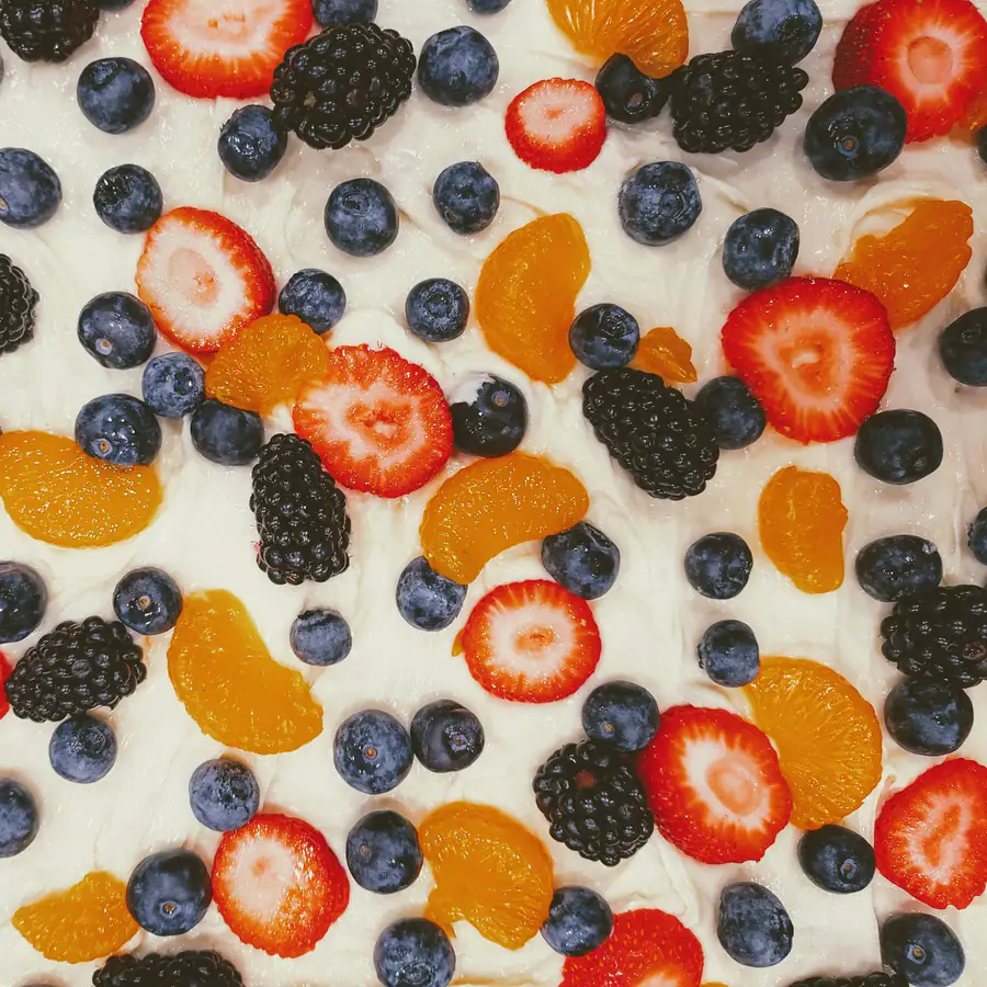 Sheet of frozen yoghurt covered with strawberries, blackberries and blueberries