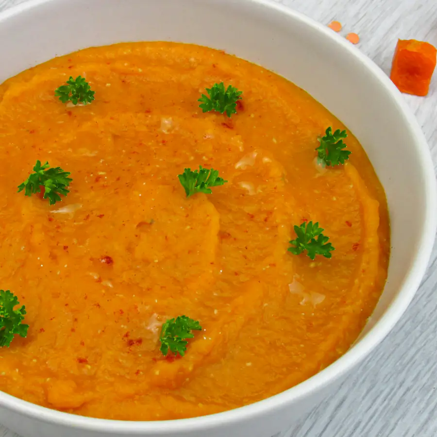 Bowl of thick golden pea soup with parsley