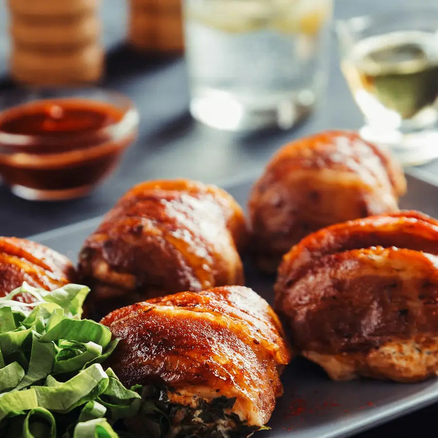 Plate of crispy chicken thighs with salad leaves