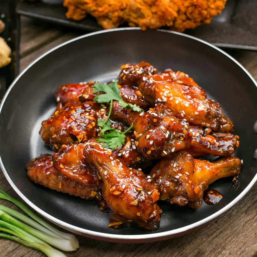Sticky honey garlic chicken wings in a pan