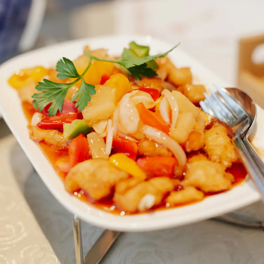 Plate of sweet and sour chicken with peppers and pineapple