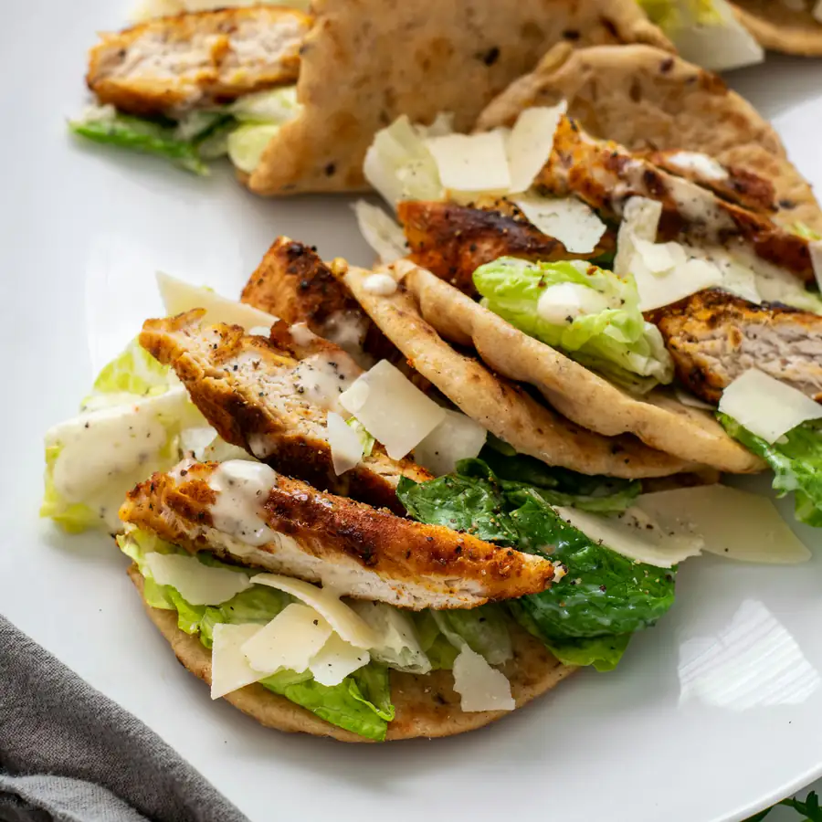 Flatbreads topped with sliced chicken and salad