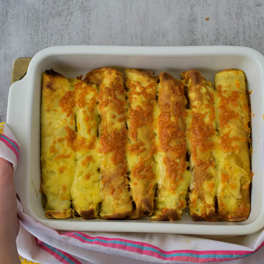 Dish of baked enchiladas with melted cheese