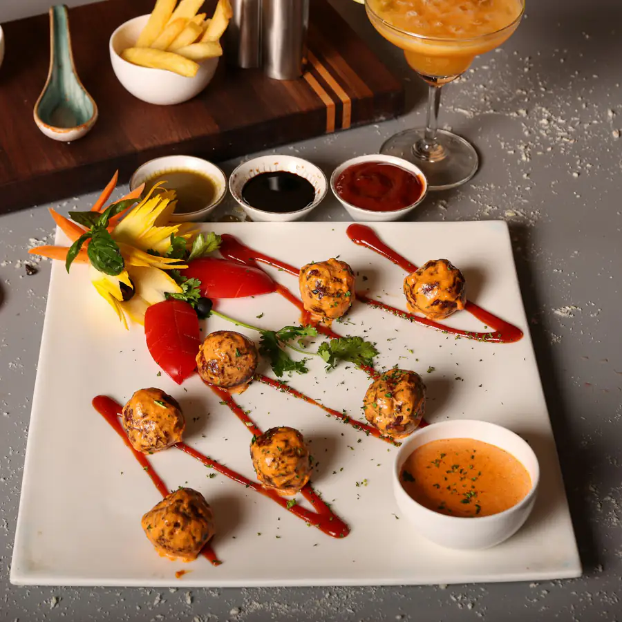 Plate of small meatballs with tomato sauce and dips