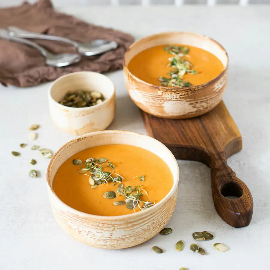 Two bowls of carrot and lentil soup