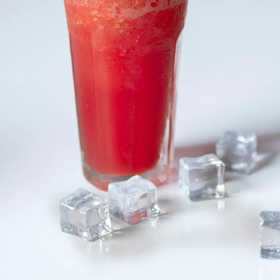 Tall glass of red juice with ice cubes