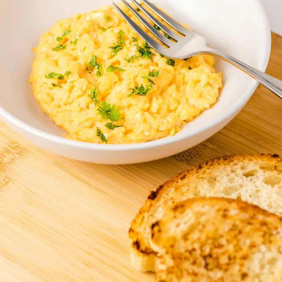 Bowl of soft scrambled eggs with toast