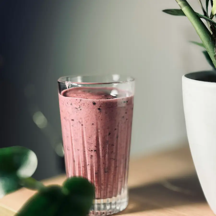 Glass of purple blueberry smoothie on a table