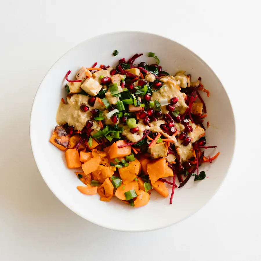 Bowl of sweet potato, red cabbage and pomegranate seeds with apple