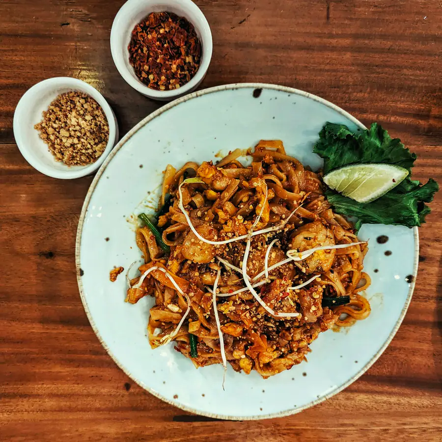 Plate of pad Thai noodles with lime and peanuts