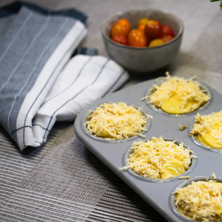 Muffin tin of egg muffins topped with cheese