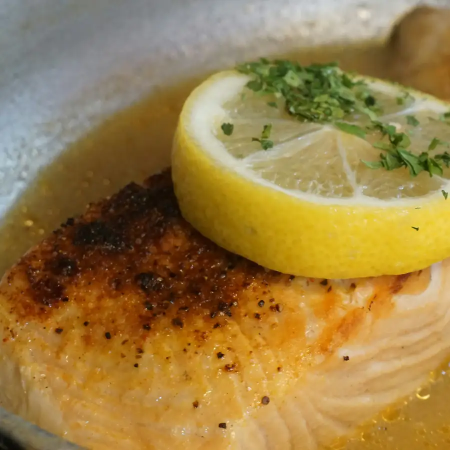 Pan fried white fish fillet with a lemon slice and parsley