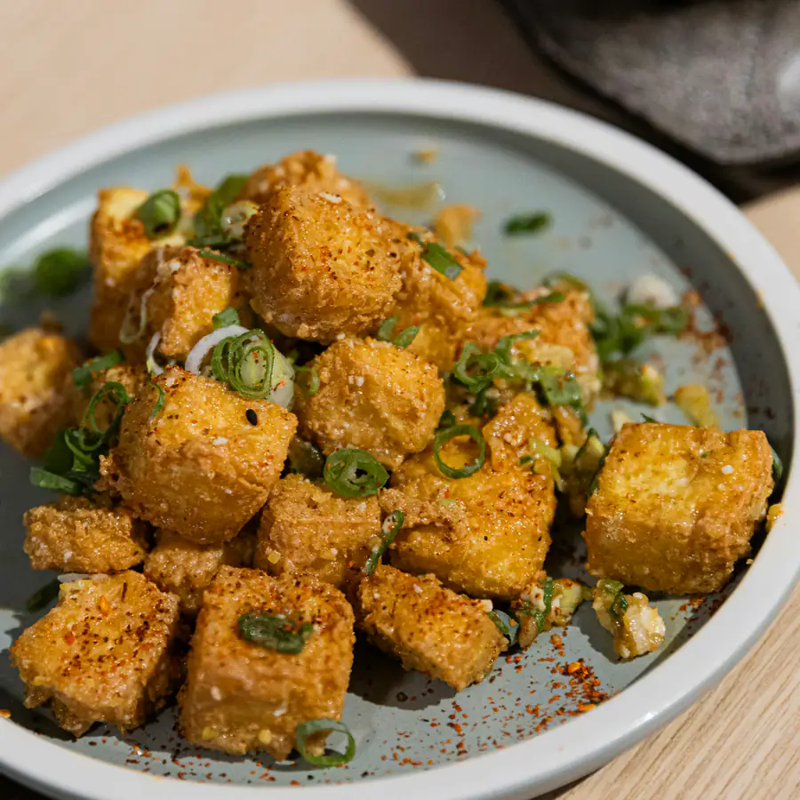 Plate of crispy tofu cubes with spring onion