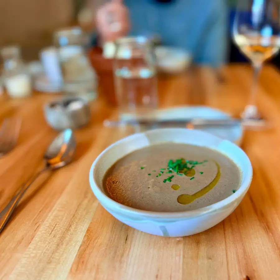 Bowl of creamy mushroom soup with a herb garnish
