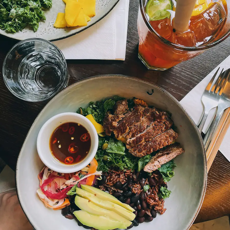 Sliced steak with salad and a dipping sauce