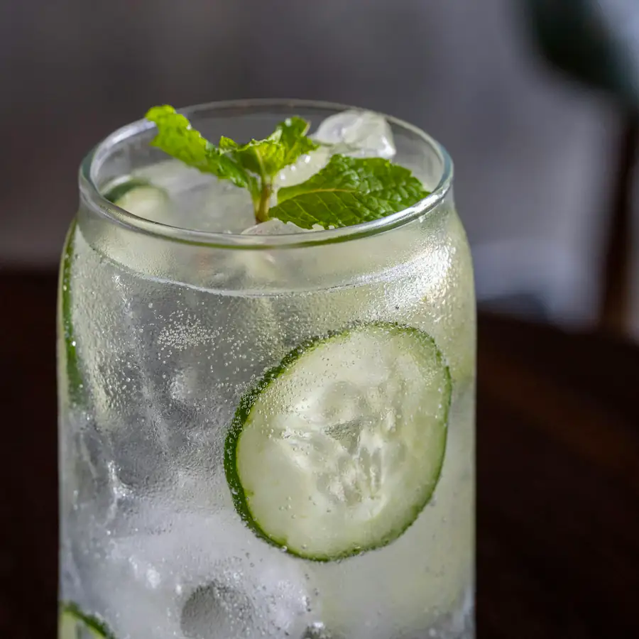 Glass of iced water with cucumber slices and mint
